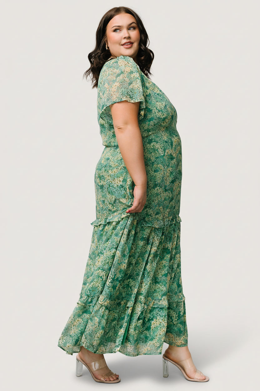 Model walking in green floral chiffon maxi dress, showcasing flow, tiered ruffle structure and the right-side slit in motion.