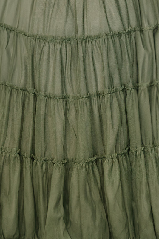 Close-up of a small sage tulle fabric swatch for the Emma dress, showing fine netted texture and soft sage color on a white background.
