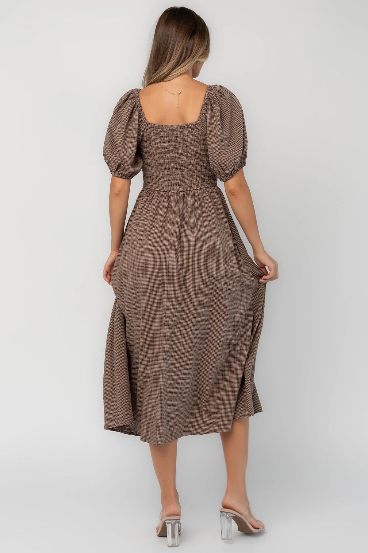 Mocha gingham midi dress with a square neckline, puff sleeves, smocked back, side pockets, and a flowing tiered skirt.