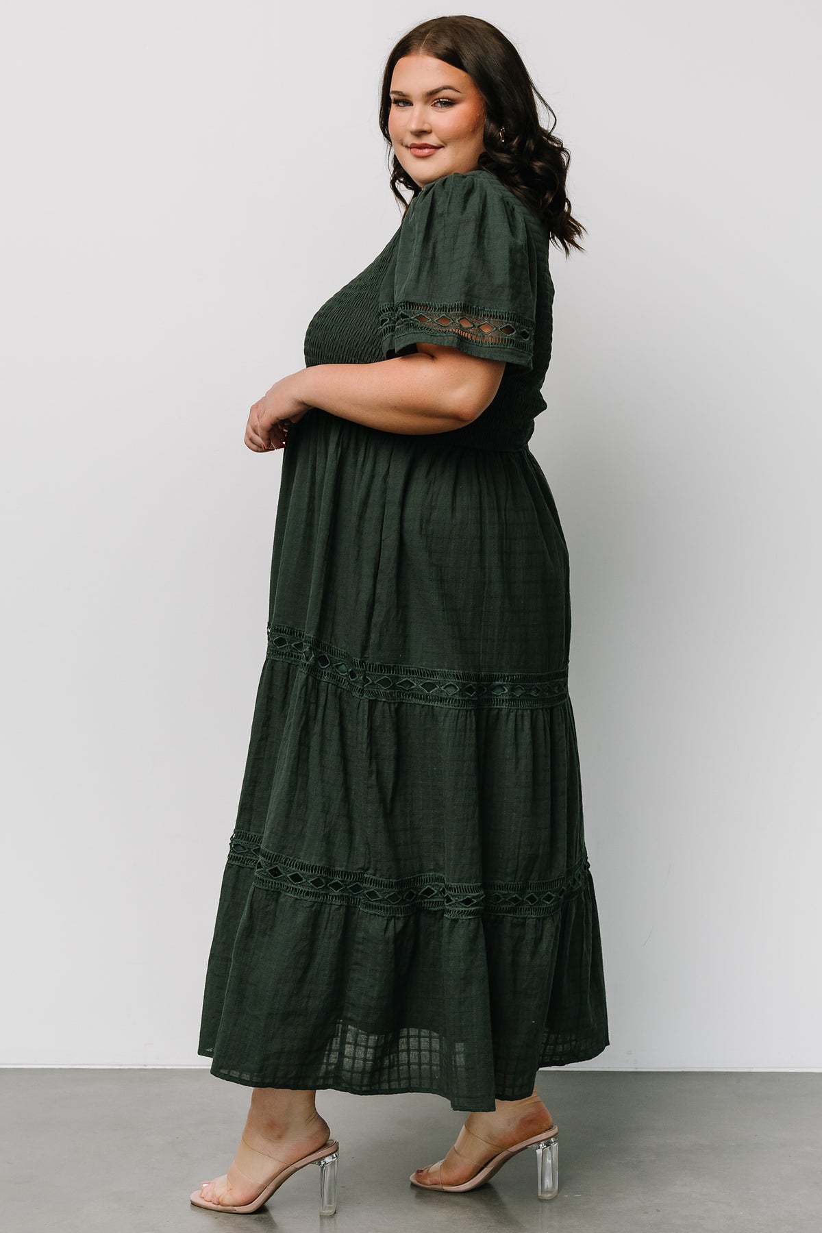 Model in dark green Loveland Geo Lace Maxi Dress walking to show skirt movement, oversized short sleeves, and hidden side pockets.