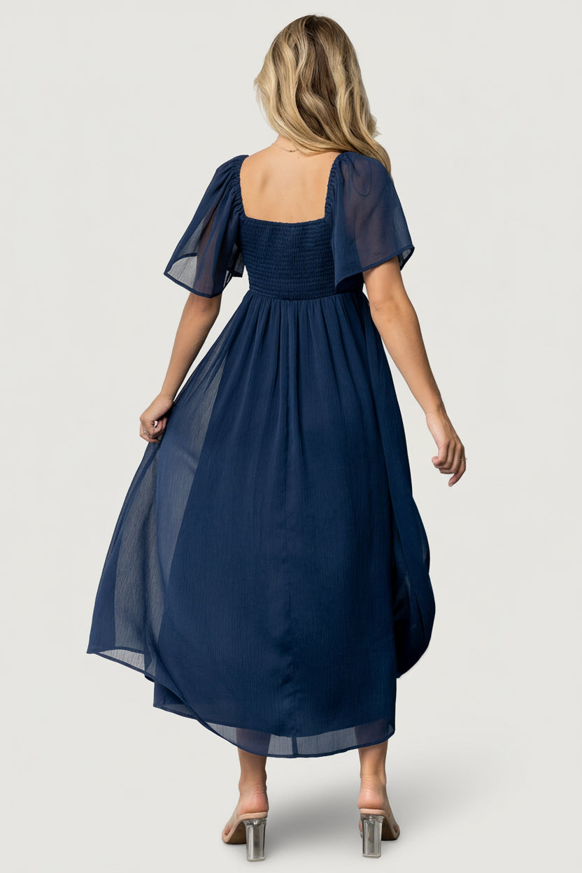 Full-length image of model in navy Nora Midi Dress showcasing midi hemline, flowy georgette fabric and feminine silhouette for event dressing.