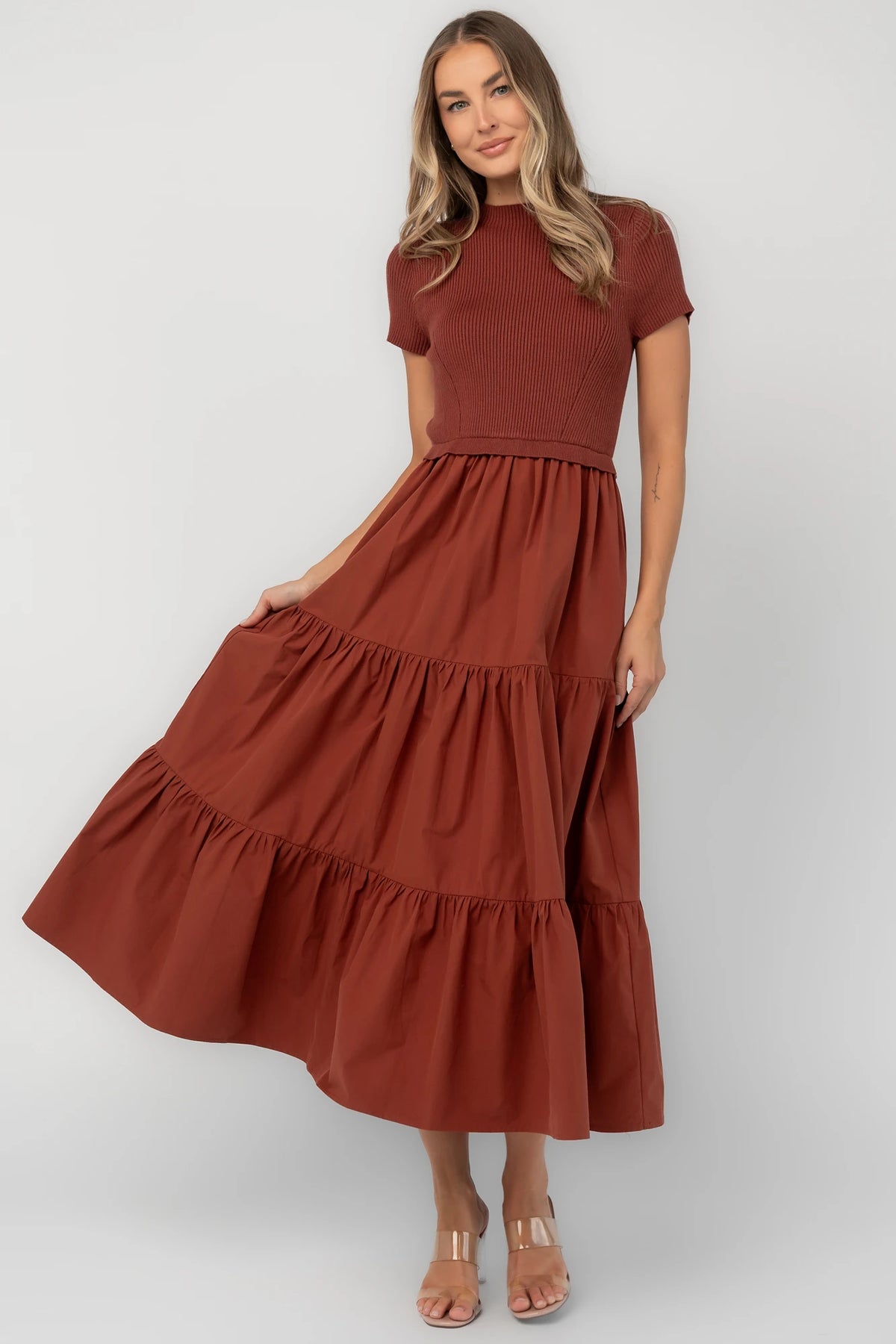 Midi dress with a ribbed knit bodice, round neckline, short sleeves, elastic waist, tiered woven skirt, and side pockets.