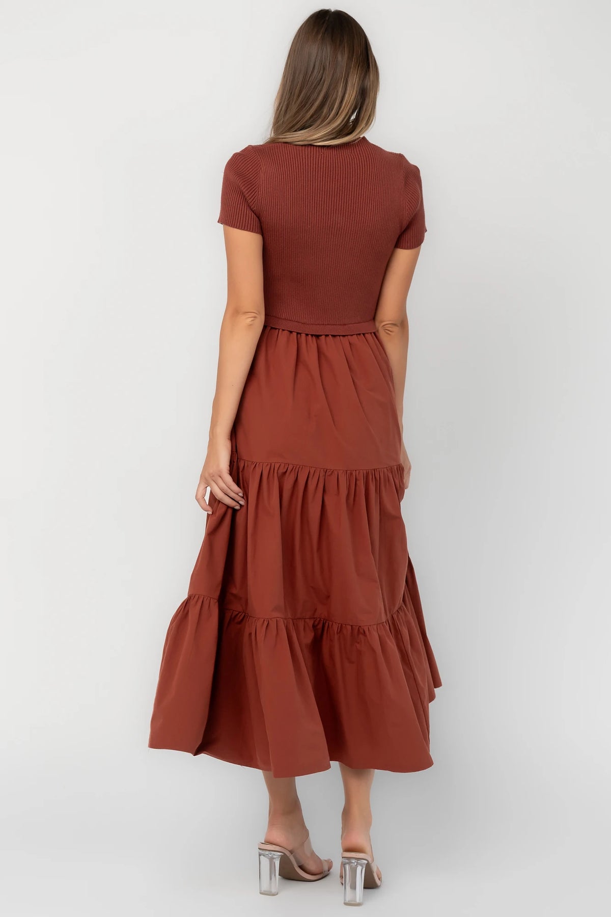 Midi dress with a ribbed knit bodice, round neckline, short sleeves, elastic waist, tiered woven skirt, and side pockets.