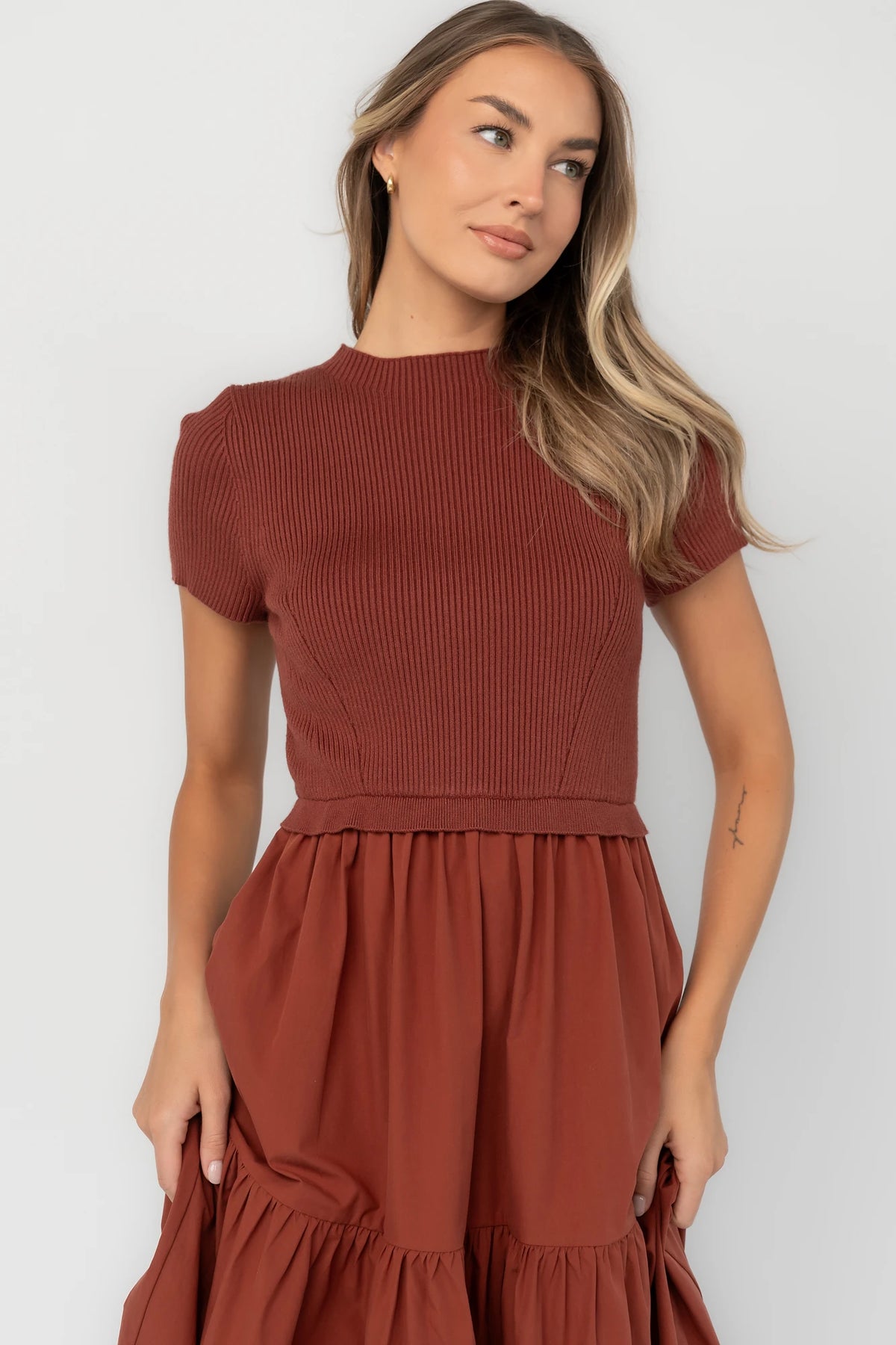 Midi dress with a ribbed knit bodice, round neckline, short sleeves, elastic waist, tiered woven skirt, and side pockets.