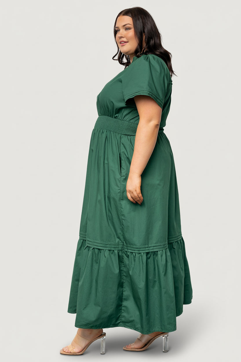 Side shot of Vera Maxi Dress in emerald emphasizing the functional side pocket, relaxed skirt drape, and natural movement of the fabric.