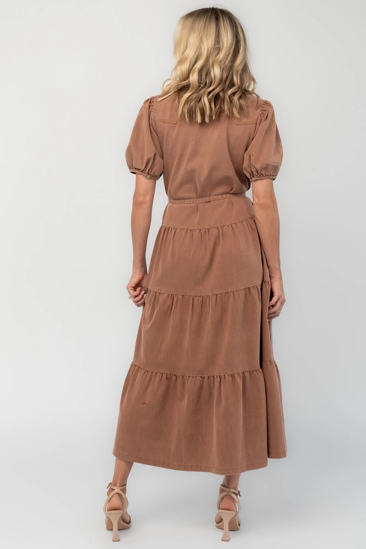 Dusty mocha midi dress with a collared neckline, gold-tone button-front closure, short puff sleeves, removable waist tie, and tiered skirt.