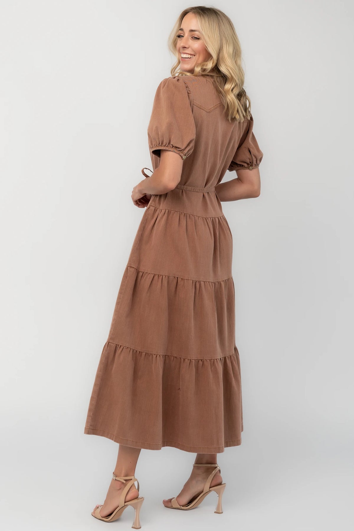 Dusty mocha midi dress with a collared neckline, gold-tone button-front closure, short puff sleeves, removable waist tie, and tiered skirt.