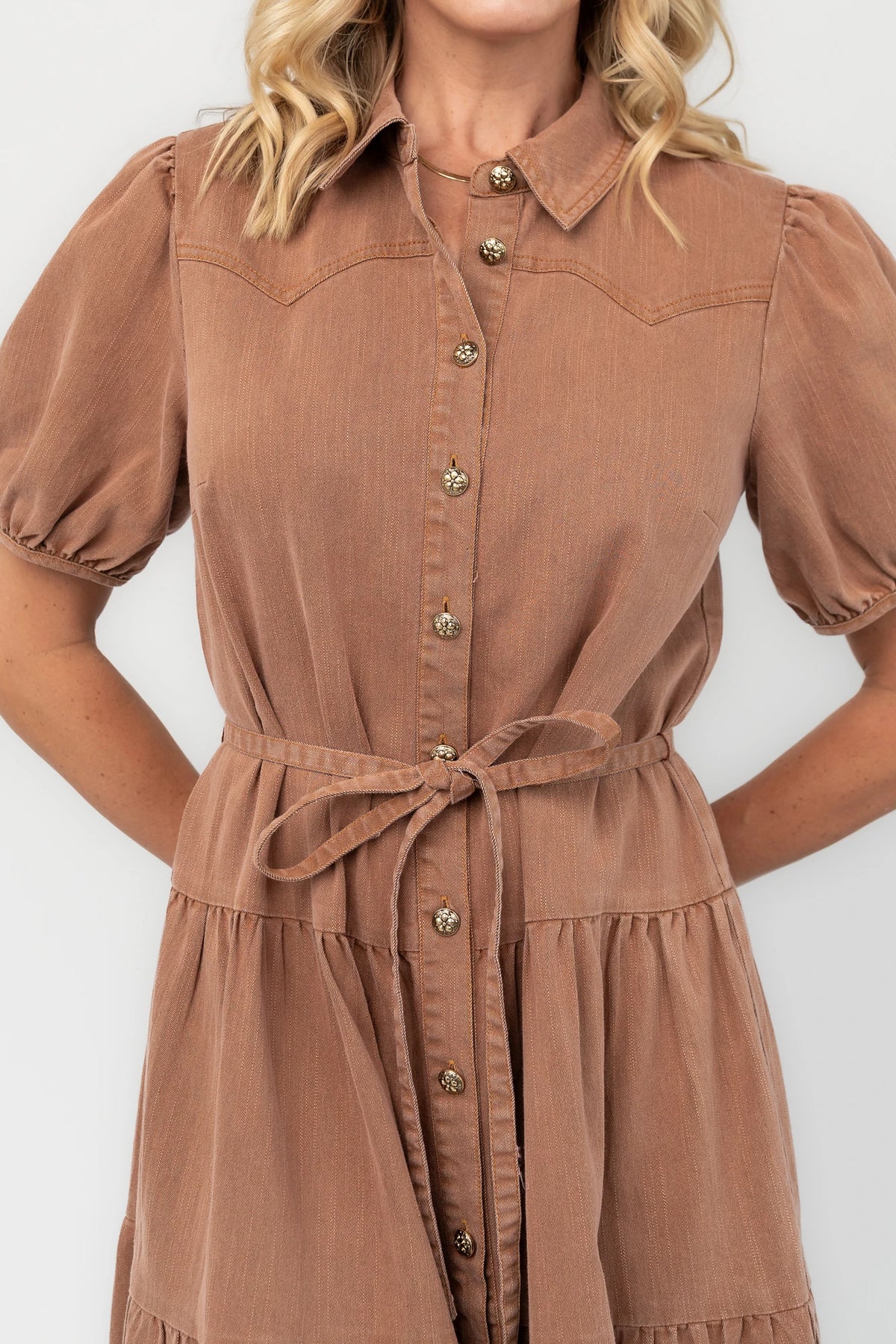 Dusty mocha midi dress with a collared neckline, gold-tone button-front closure, short puff sleeves, removable waist tie, and tiered skirt.