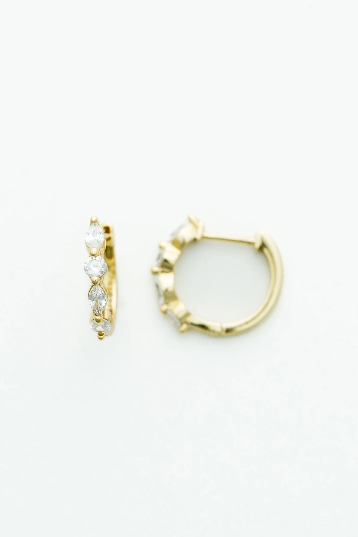Gold hoop earrings adorned with clear crystal stones in mixed round and marquise shapes.