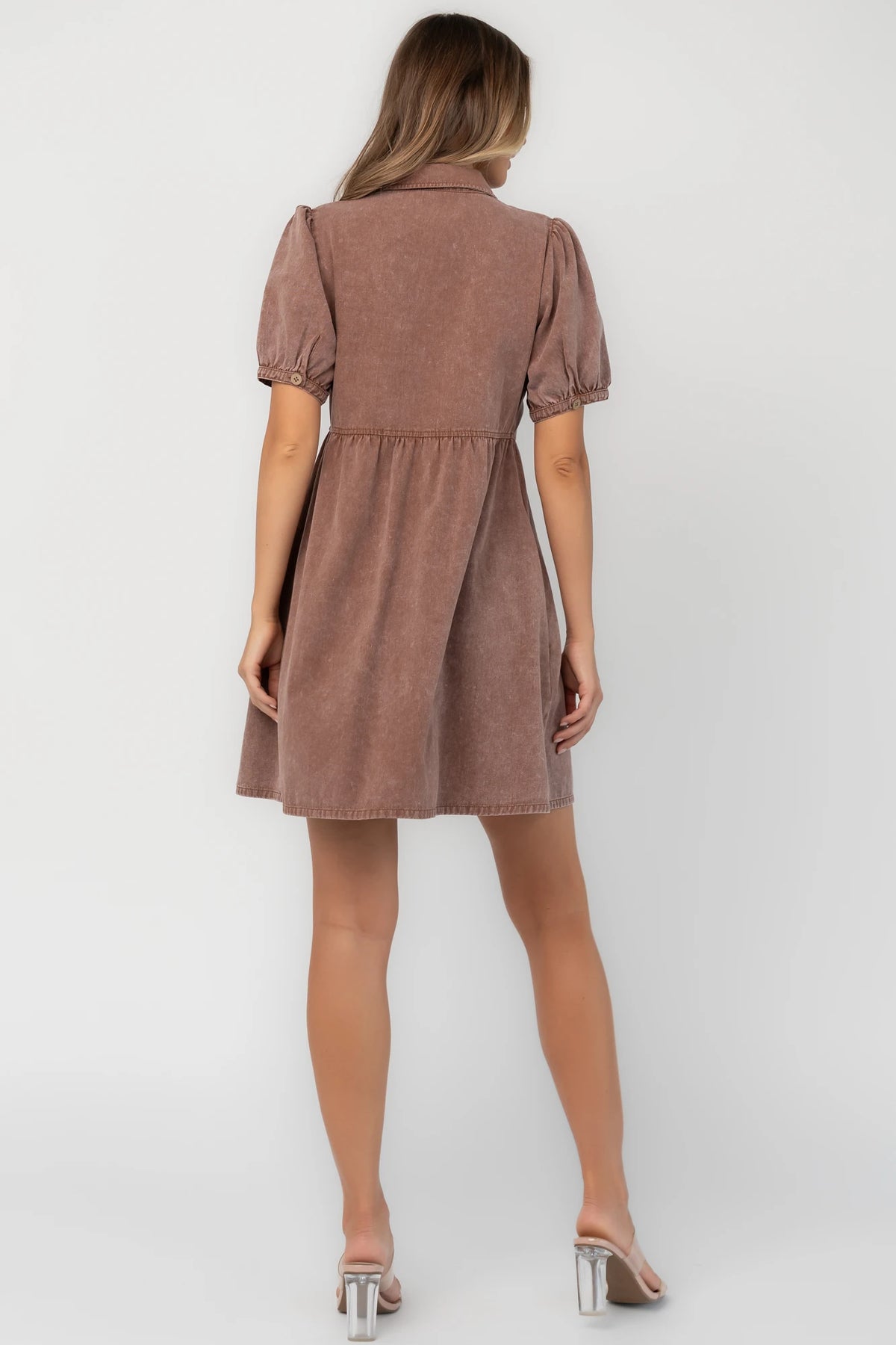 Dusty mocha mineral wash mini dress with a collared neckline, button-front closure, short puff sleeves, empire waist, and relaxed silhouette.