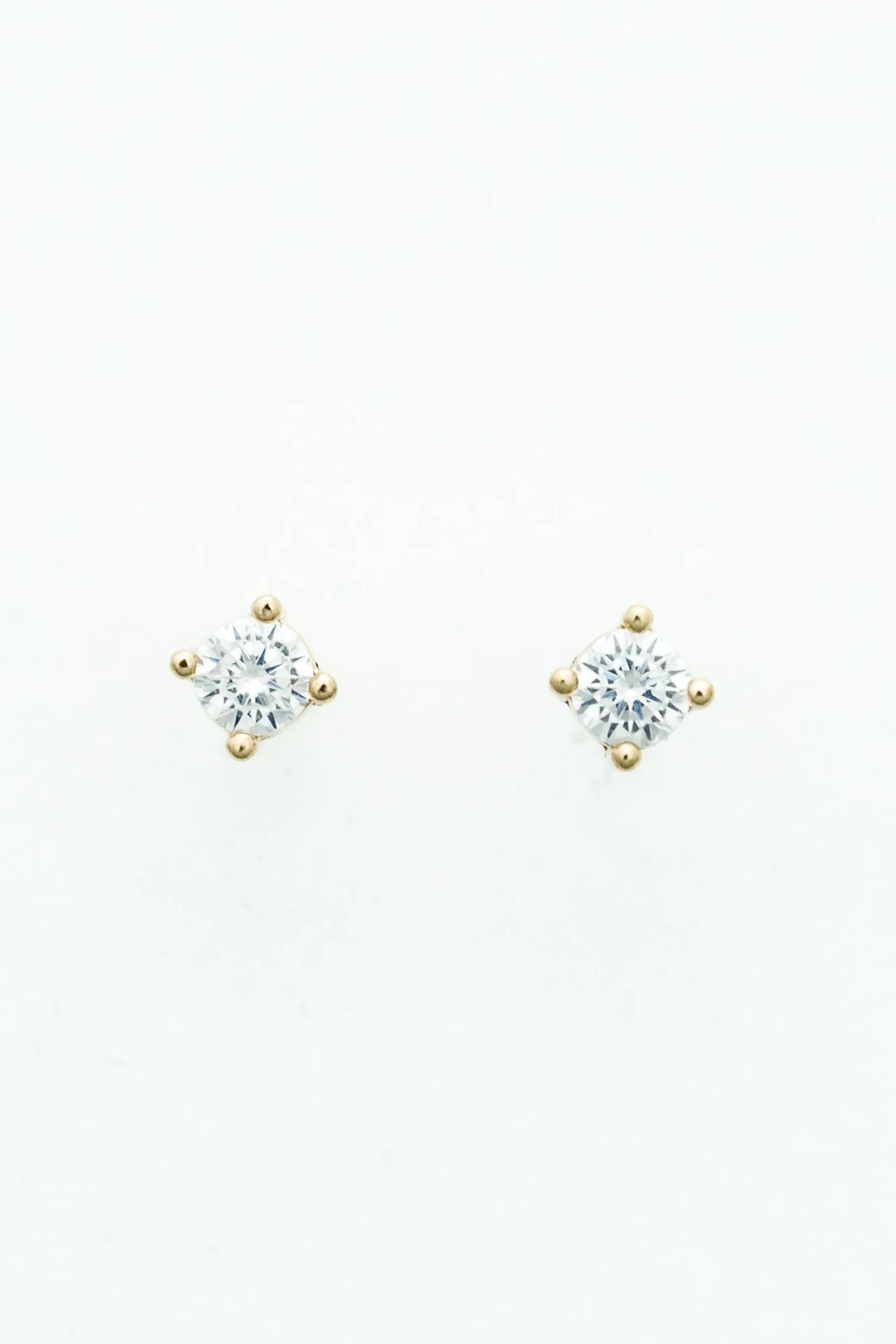 Round crystal stud earrings set in a gold-tone prong setting.