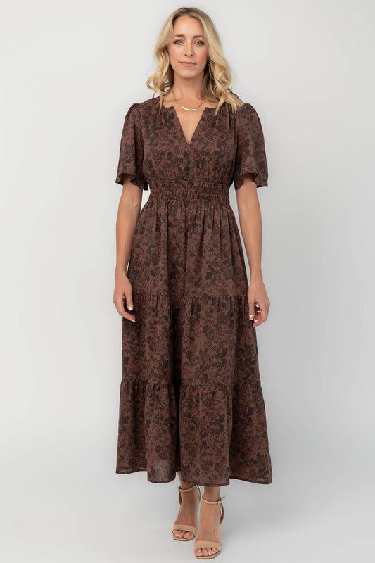 Espresso floral maxi dress with a split V-neckline, flutter sleeves, smocked waist, and flowing tiered skirt.