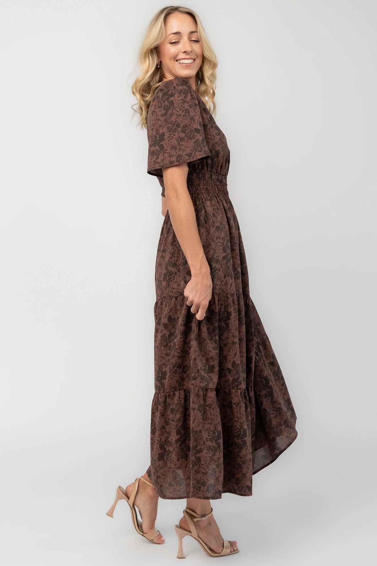 Espresso floral maxi dress with a split V-neckline, flutter sleeves, smocked waist, and flowing tiered skirt.