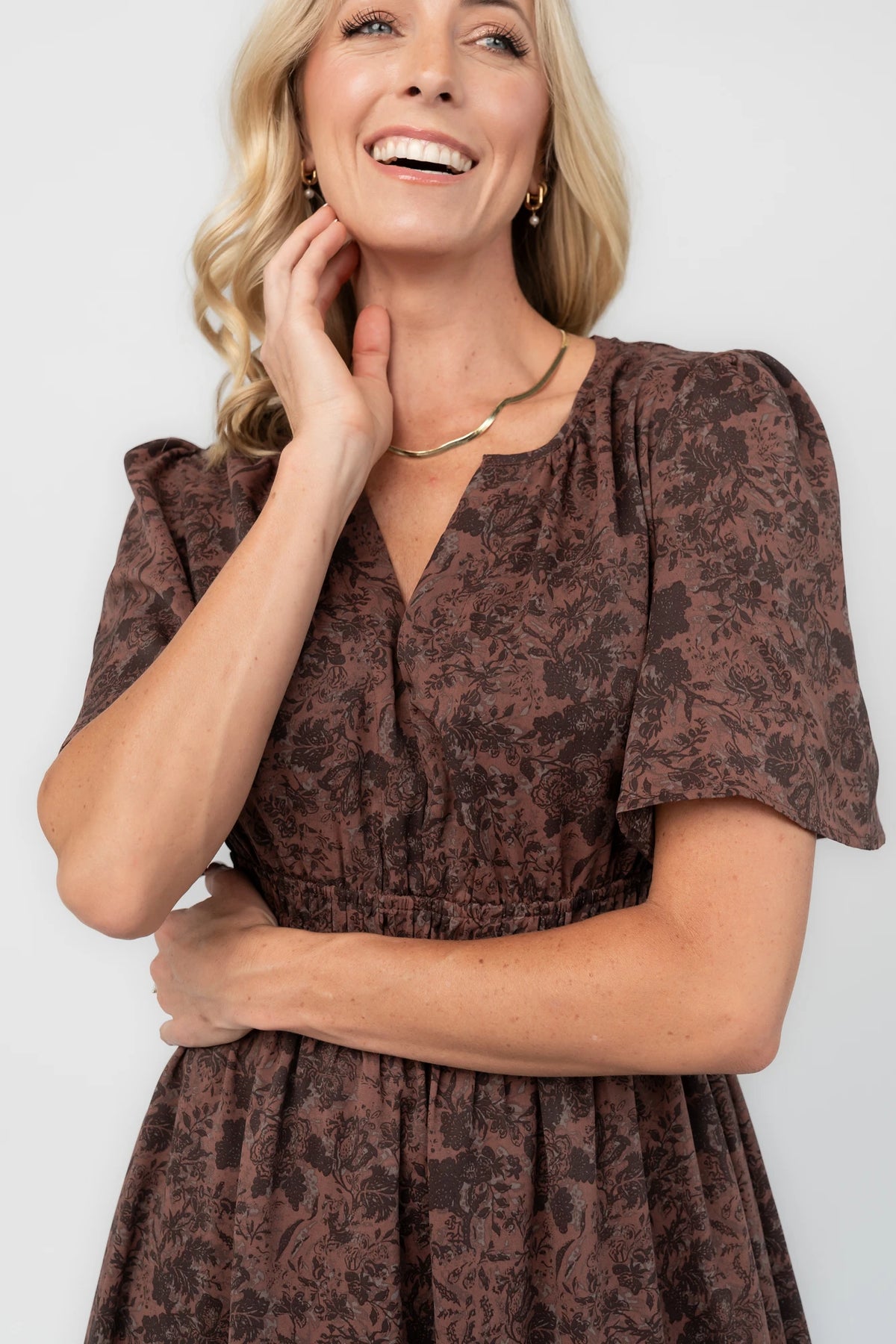 Espresso floral maxi dress with a split V-neckline, flutter sleeves, smocked waist, and flowing tiered skirt.
