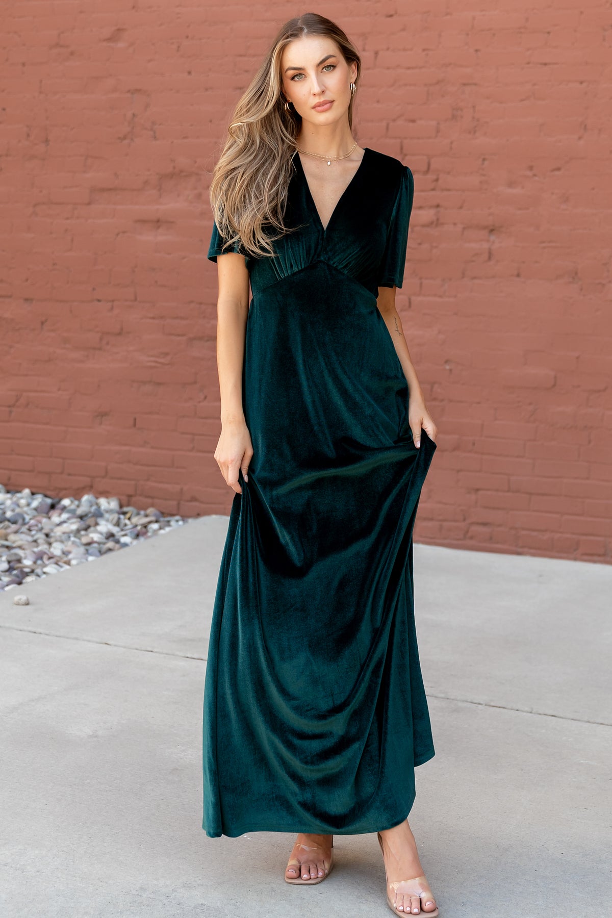 Close-up of emerald velvet texture and gathered bust with upturned-v empire waist on the Vivian maxi dress, showing fabric sheen.