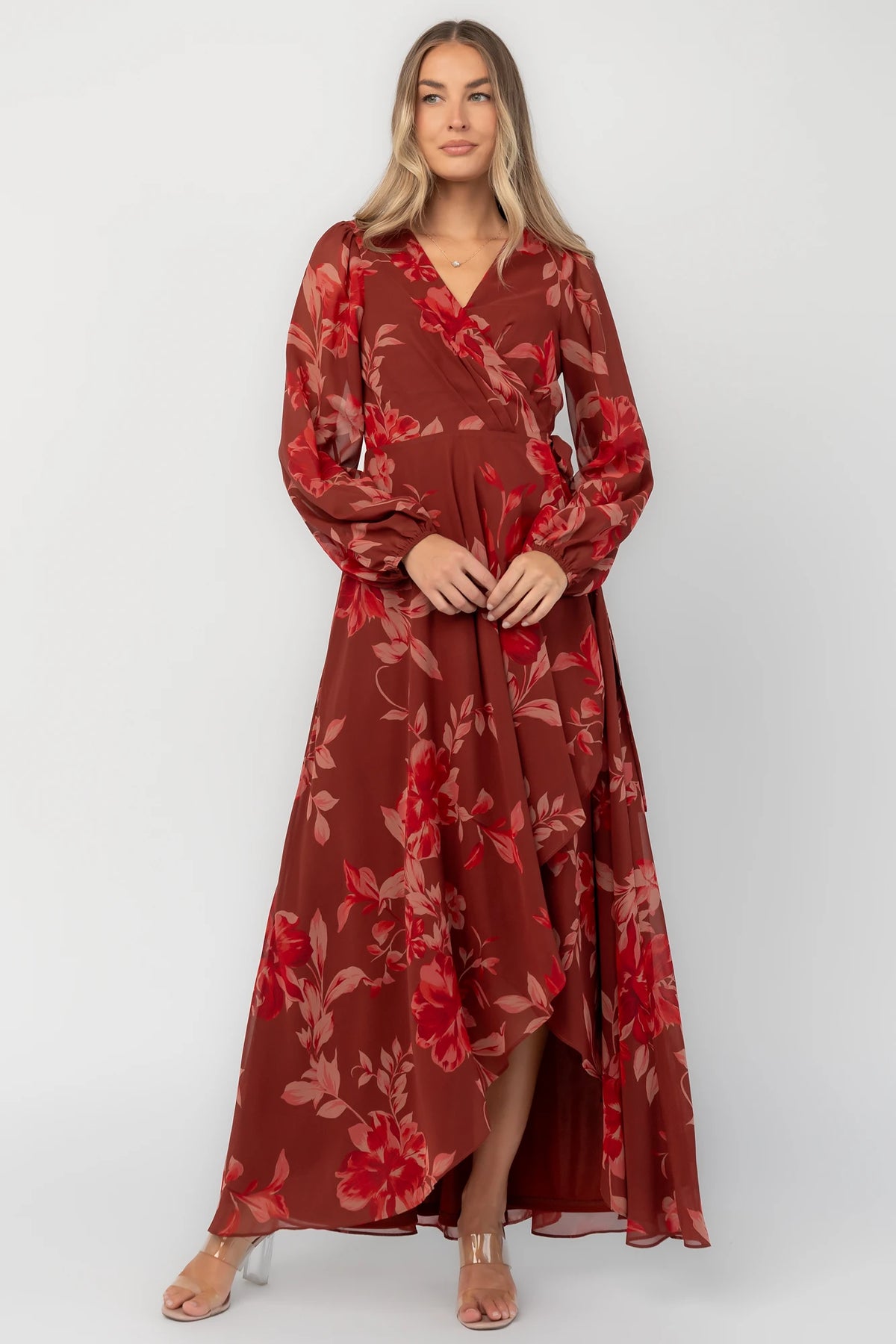 Rust multi floral chiffon maxi dress with a faux wrap neckline, long balloon sleeves, adjustable waist tie, and a high-low skirt.