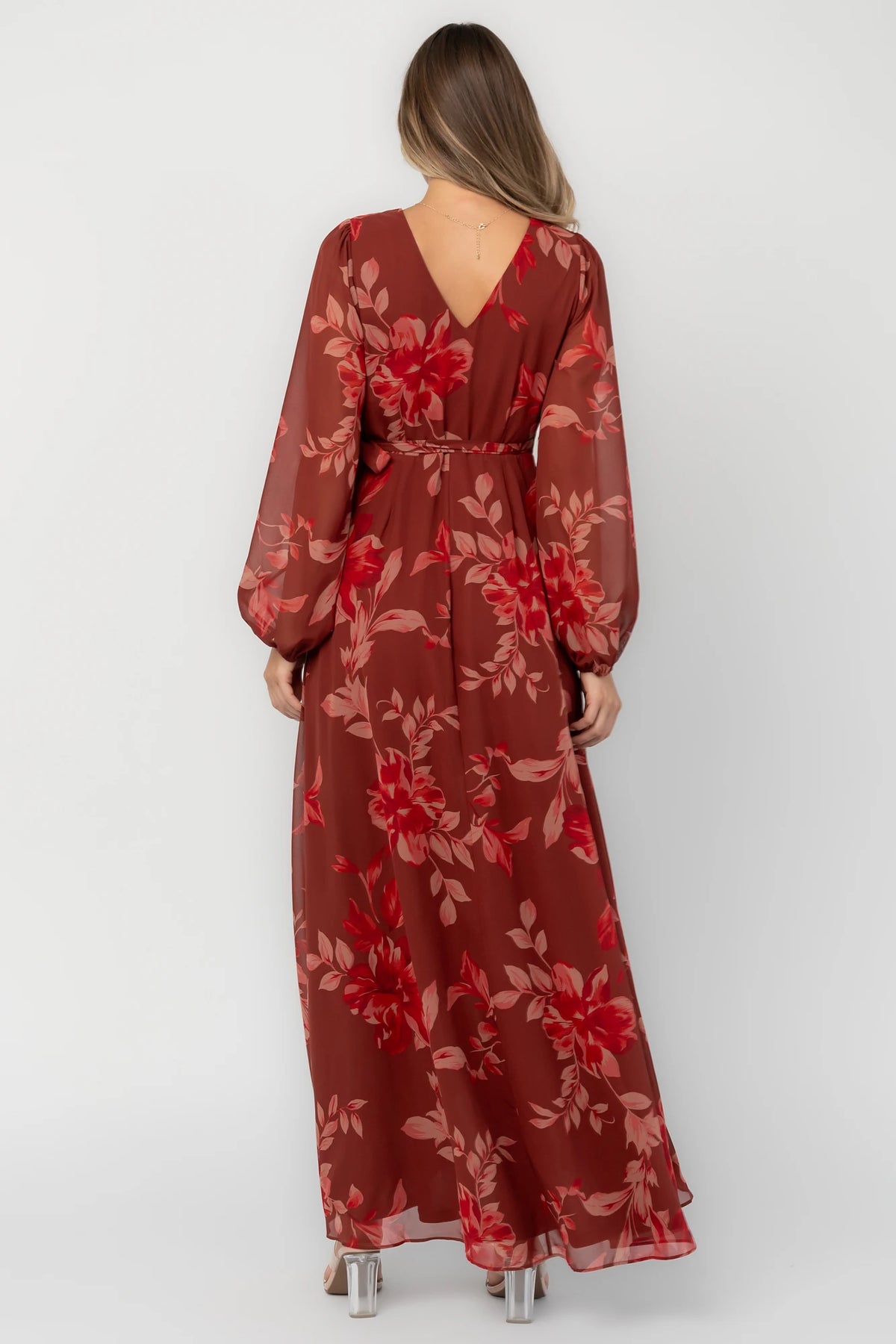 Rust multi floral chiffon maxi dress with a faux wrap neckline, long balloon sleeves, adjustable waist tie, and a high-low skirt.