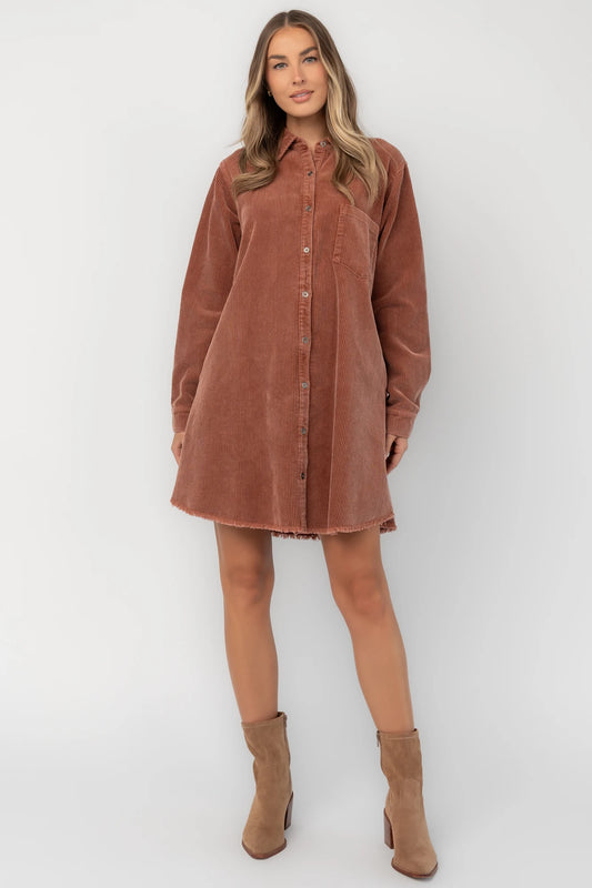 Dusty clay corduroy button-front shirt jacket with a collared neckline, oversized fit, chest pocket, long sleeves, and a rounded high-low hem.