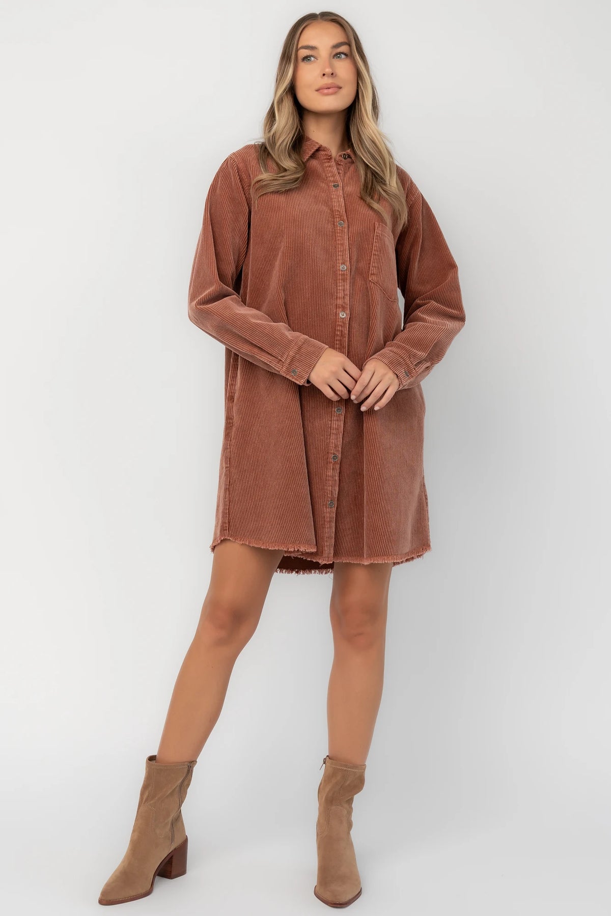 Dusty clay corduroy button-front shirt jacket with a collared neckline, oversized fit, chest pocket, long sleeves, and a rounded high-low hem.