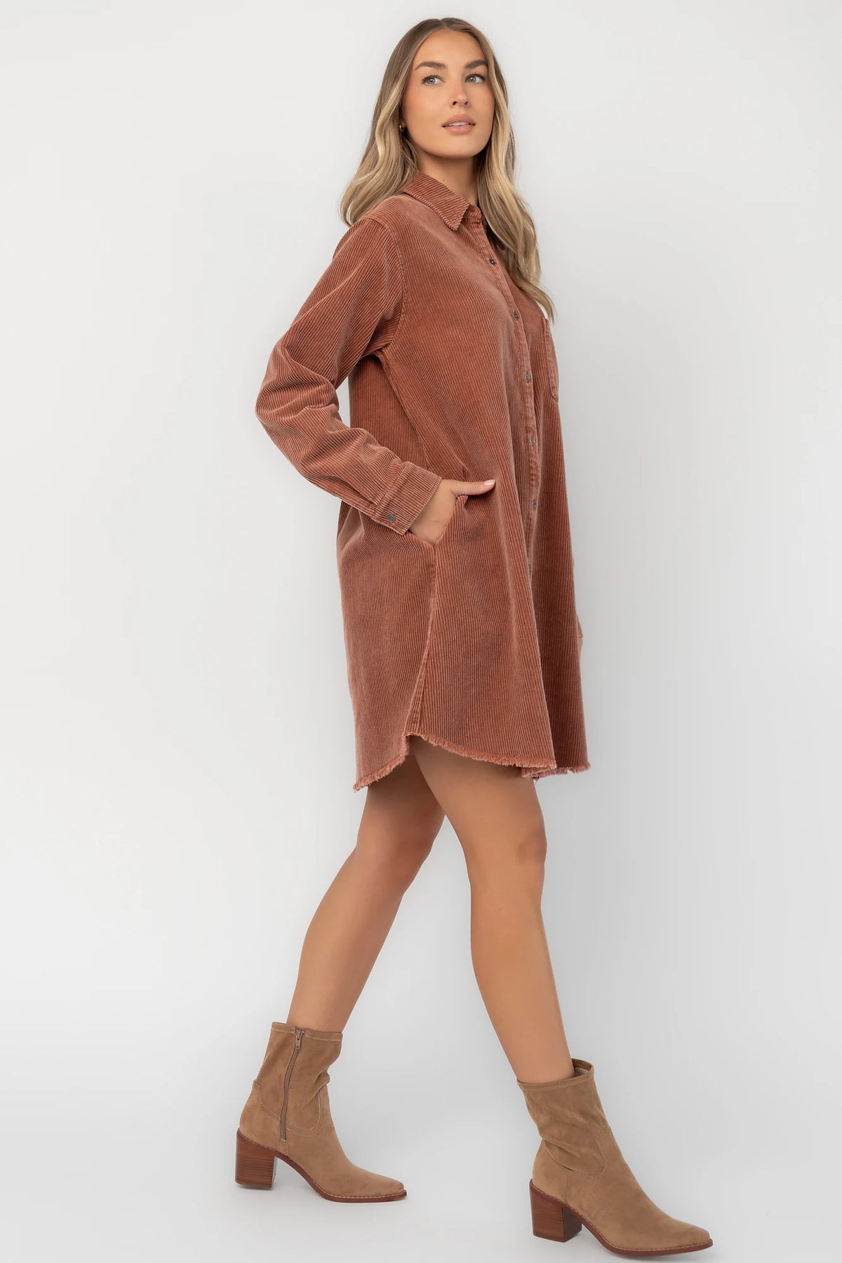 Dusty clay corduroy button-front shirt jacket with a collared neckline, oversized fit, chest pocket, long sleeves, and a rounded high-low hem.