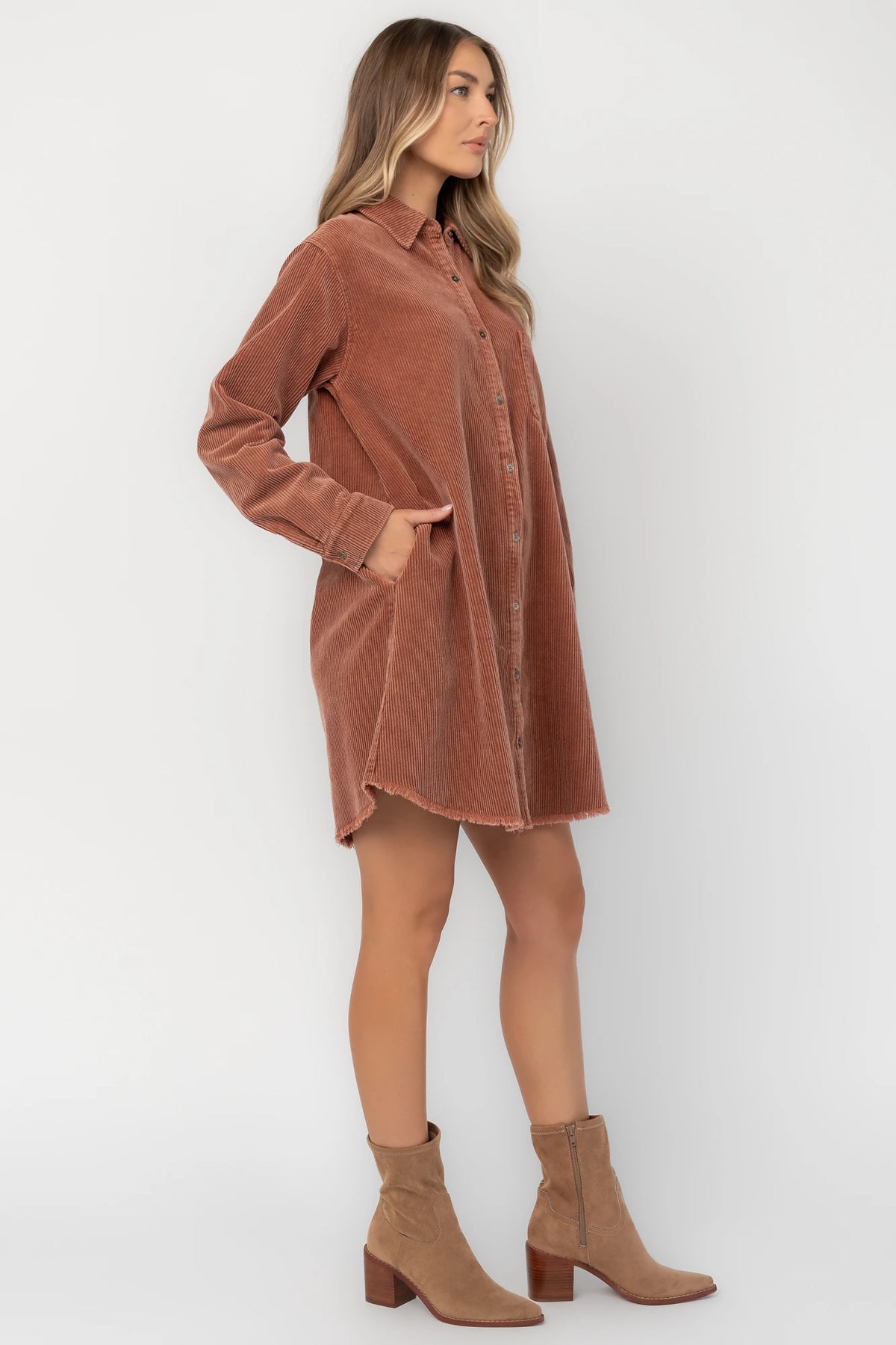 Dusty clay corduroy button-front shirt jacket with a collared neckline, oversized fit, chest pocket, long sleeves, and a rounded high-low hem.