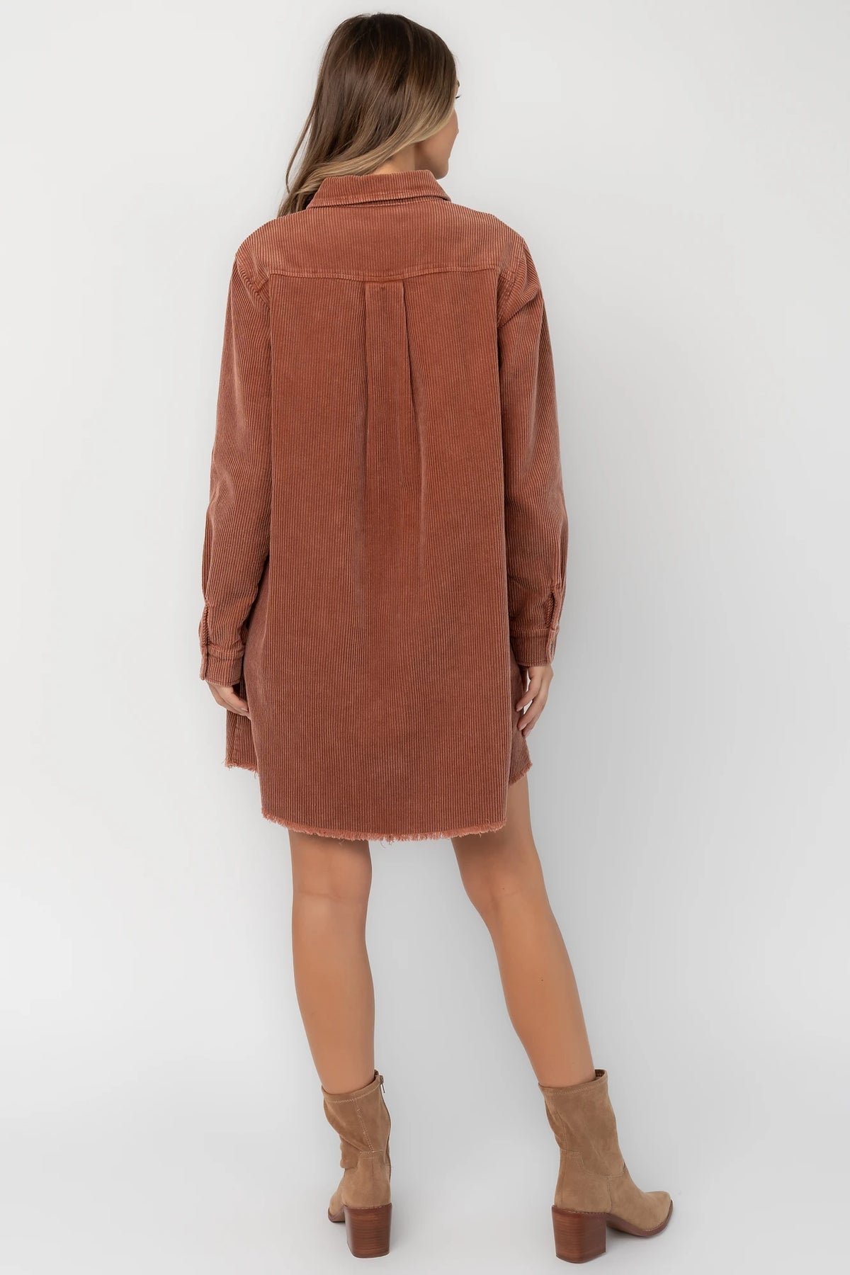 Dusty clay corduroy button-front shirt jacket with a collared neckline, oversized fit, chest pocket, long sleeves, and a rounded high-low hem.
