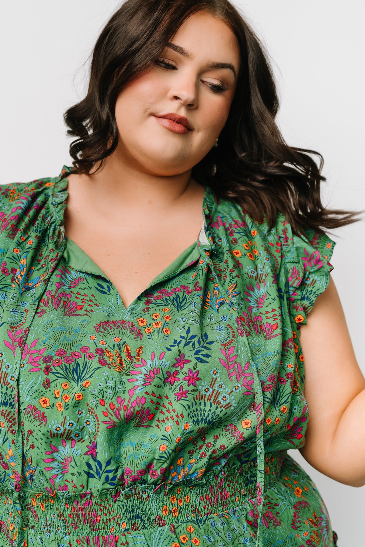 Detail shot of the Rio Short Dress fabric and print, focusing on the green multi floral pattern, soft rayon drape, and subtle ruffle edges at hem and sleeves.