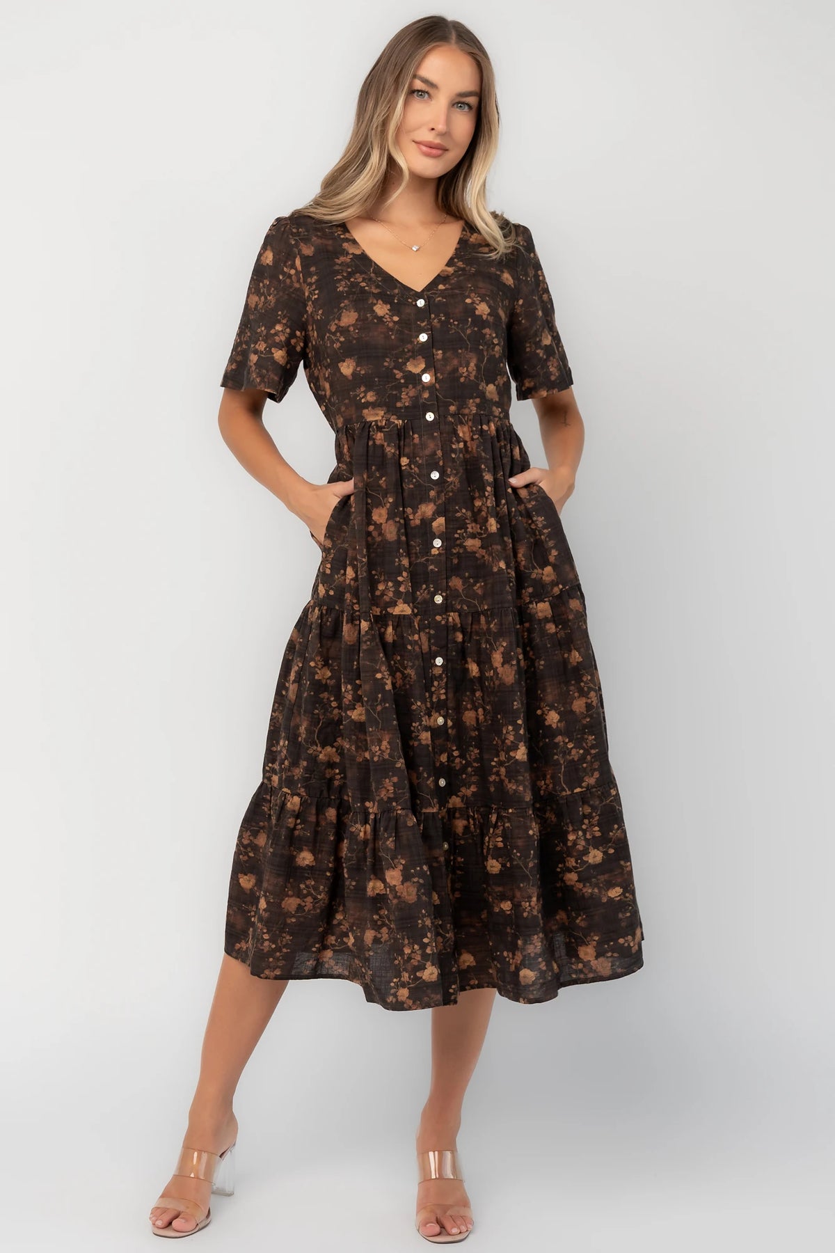 Clove floral midi dress with a V-neckline, functional button-front closure, puff sleeves, elastic back waist, side pockets, and a tiered skirt.