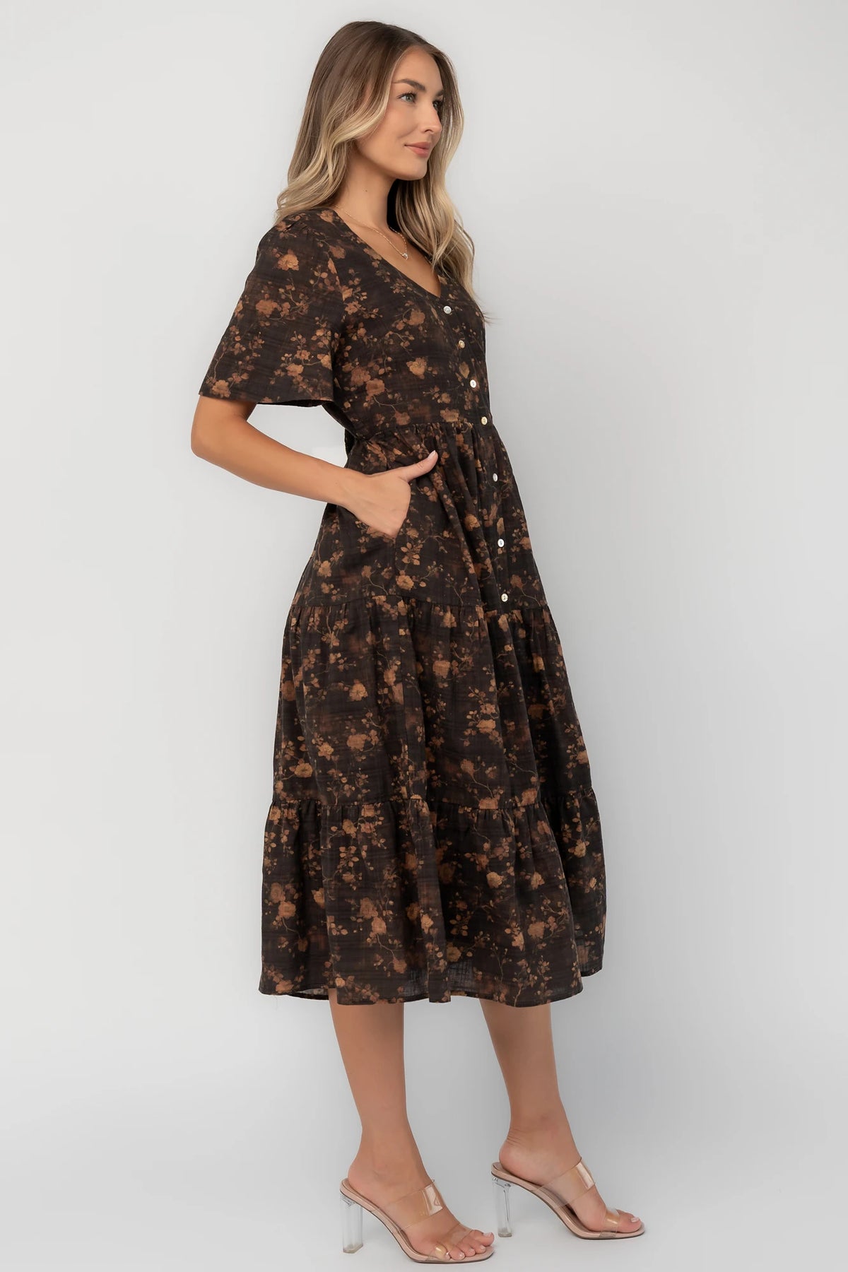Clove floral midi dress with a V-neckline, functional button-front closure, puff sleeves, elastic back waist, side pockets, and a tiered skirt.
