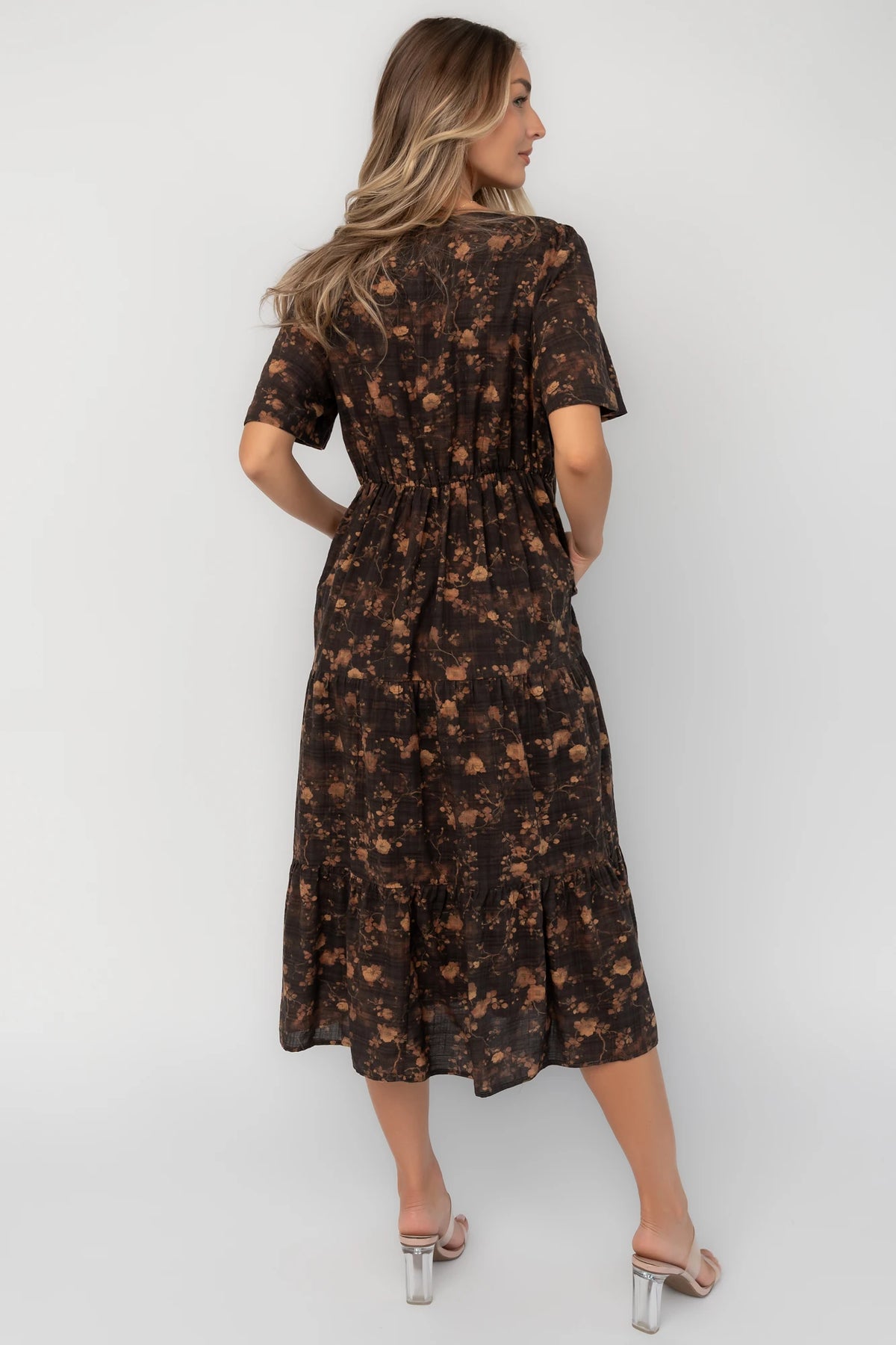 Clove floral midi dress with a V-neckline, functional button-front closure, puff sleeves, elastic back waist, side pockets, and a tiered skirt.