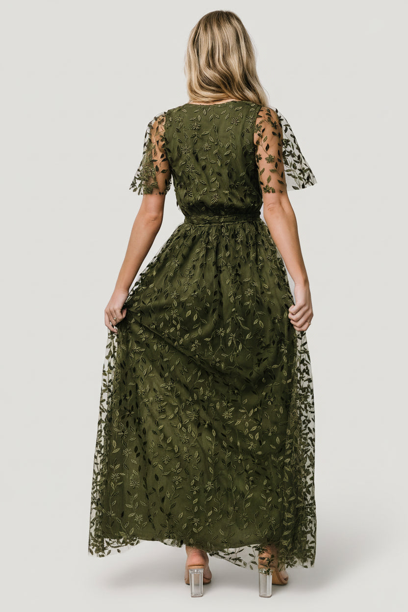 Back view of the olive Marseille maxi dress showing inverted lining seam, elasticated waist with separate tie, and raw-cut hemline detail.