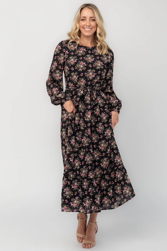 Floral midi dress with a round neckline, long sleeves, smocked back bodice, removable waist tie, tiered skirt, and back keyhole closure.