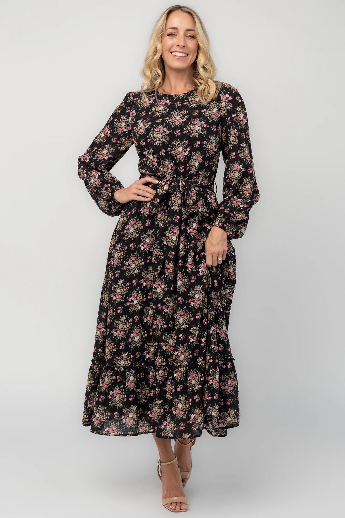 Floral midi dress with a round neckline, long sleeves, smocked back bodice, removable waist tie, tiered skirt, and back keyhole closure.
