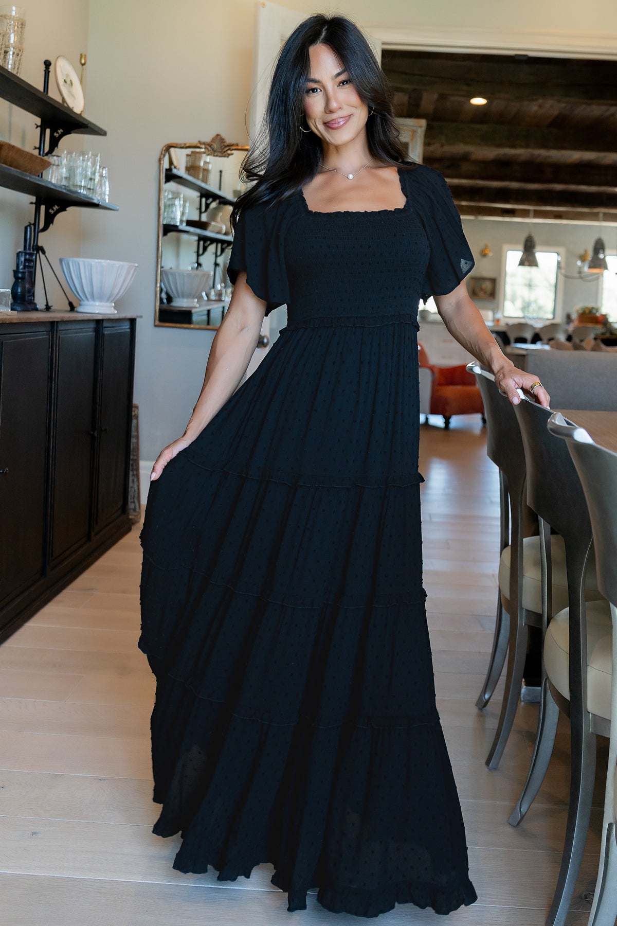 Back and side view of black Lenora maxi dress revealing ruffle tiers, elastic waist detail, and how the lining falls to mid-thigh for modest coverage.