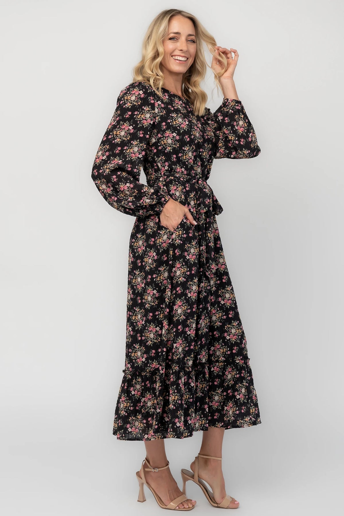 Floral midi dress with a round neckline, long sleeves, smocked back bodice, removable waist tie, tiered skirt, and back keyhole closure.