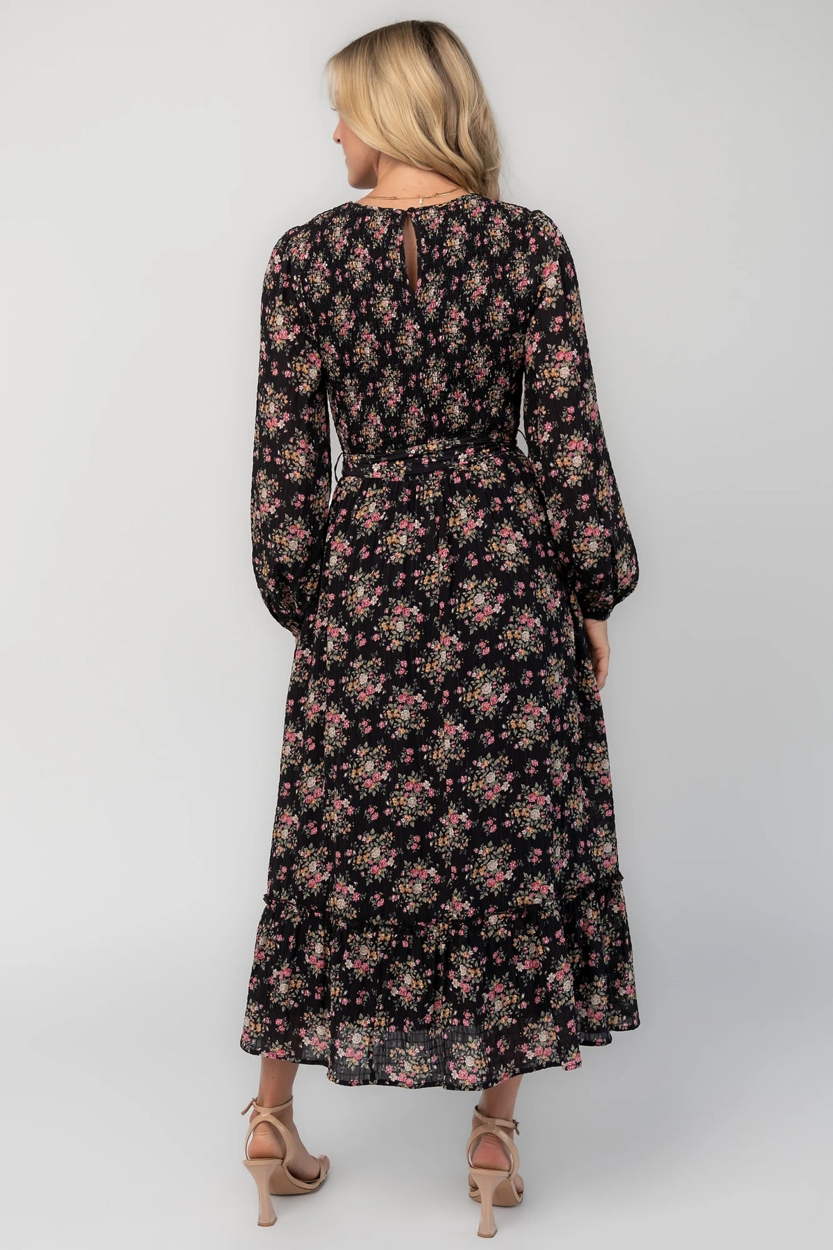 Floral midi dress with a round neckline, long sleeves, smocked back bodice, removable waist tie, tiered skirt, and back keyhole closure.