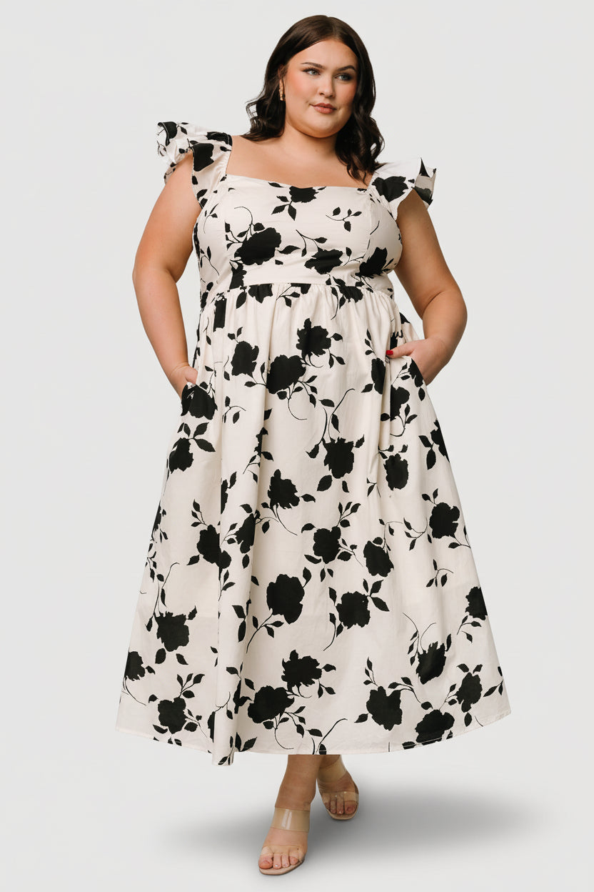 Close-up of dress fabric and print: ivory ground with contrasting black floral motifs and textured cotton weave.