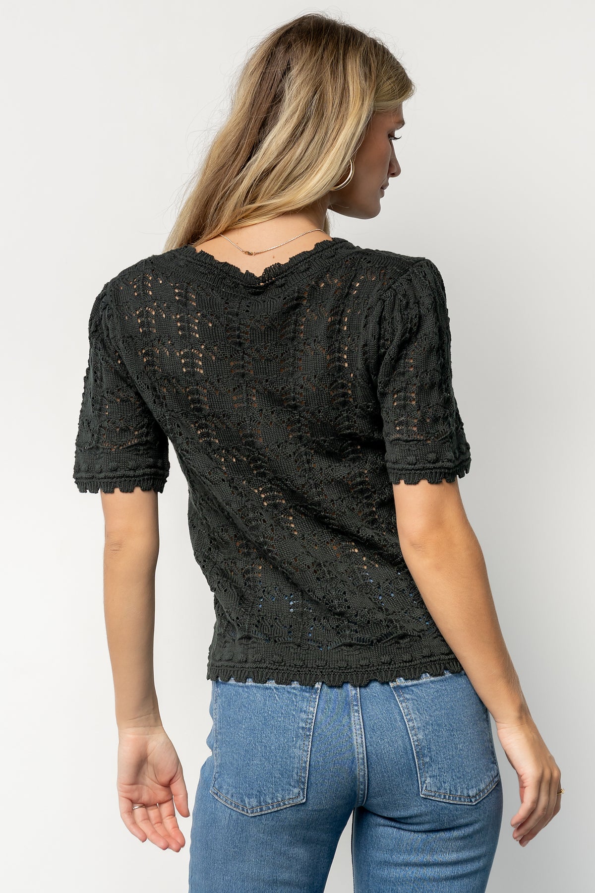 Flat-lay of the Serenity Knit Sweater Top in dark green displaying scalloped edges, short sleeves, and unlined knit construction.