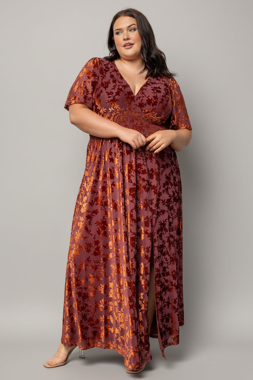 Close-up of embossed velvet texture and smocked waist on the Veronica maxi dress in rust, highlighting fabric sheen and detail.
