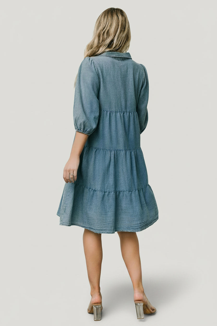 Model walking in Sari chambray babydoll dress, showing the lightweight cotton weave and natural movement of the tiered skirt.