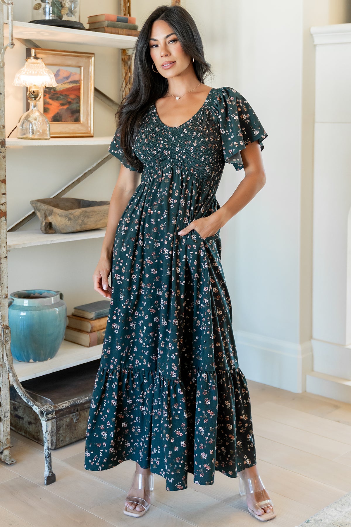 Full-length image of the Jerah smocked midi dress in deep jade floral on a model, showing V-neck, smocked bodice, and skirt movement.