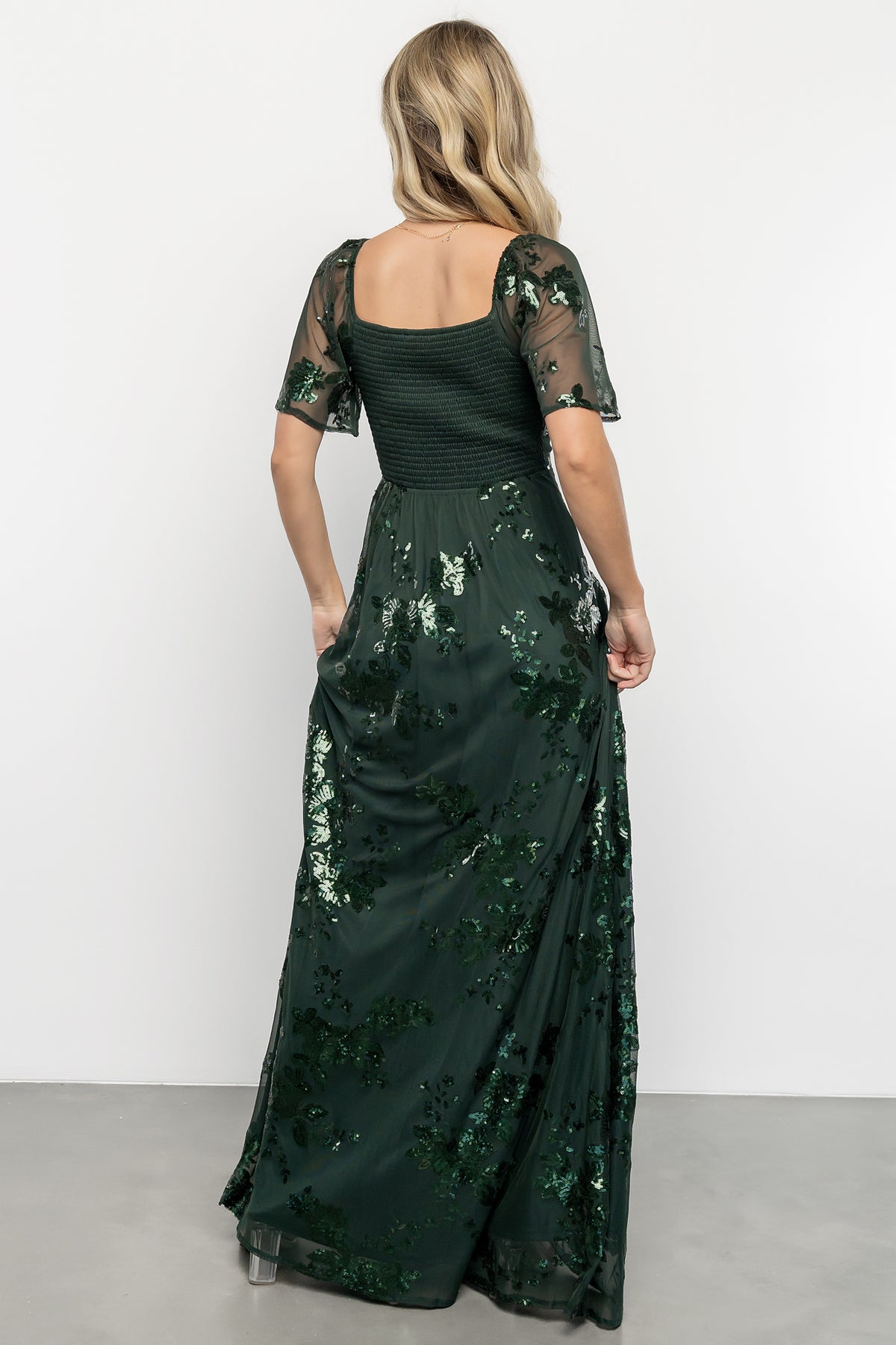 Back view of the Karina sequin maxi dress showing smocked back bodice, elastic back waist, and the flowing maxi-length skirt.