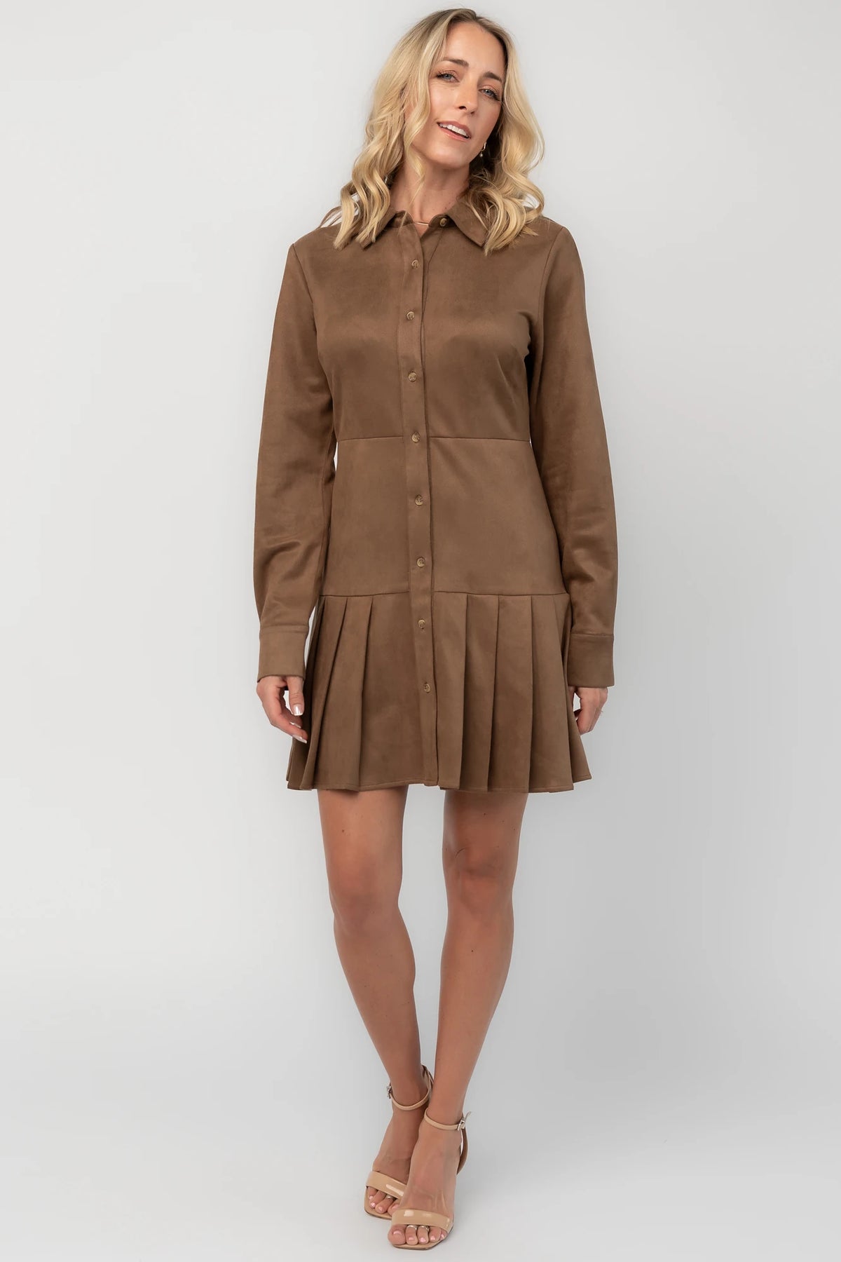 Coffee faux suede mini dress with a collared neckline, button-front closure, long sleeves, fitted waist, and pleated skirt.