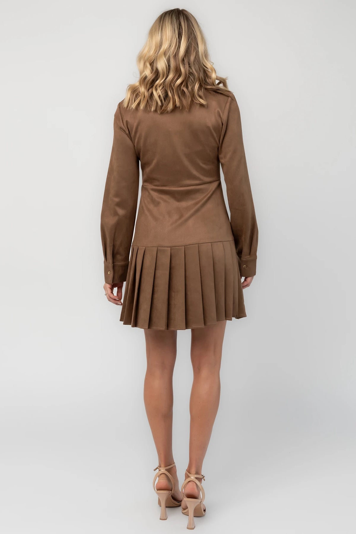 Coffee faux suede mini dress with a collared neckline, button-front closure, long sleeves, fitted waist, and pleated skirt.