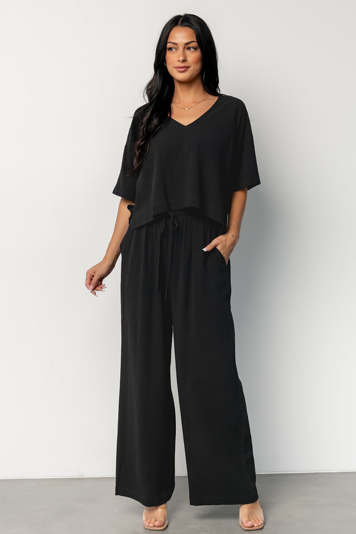 Three-quarter view of the black Timbre set showing V-neck top, center fabric detail, and relaxed silhouette.