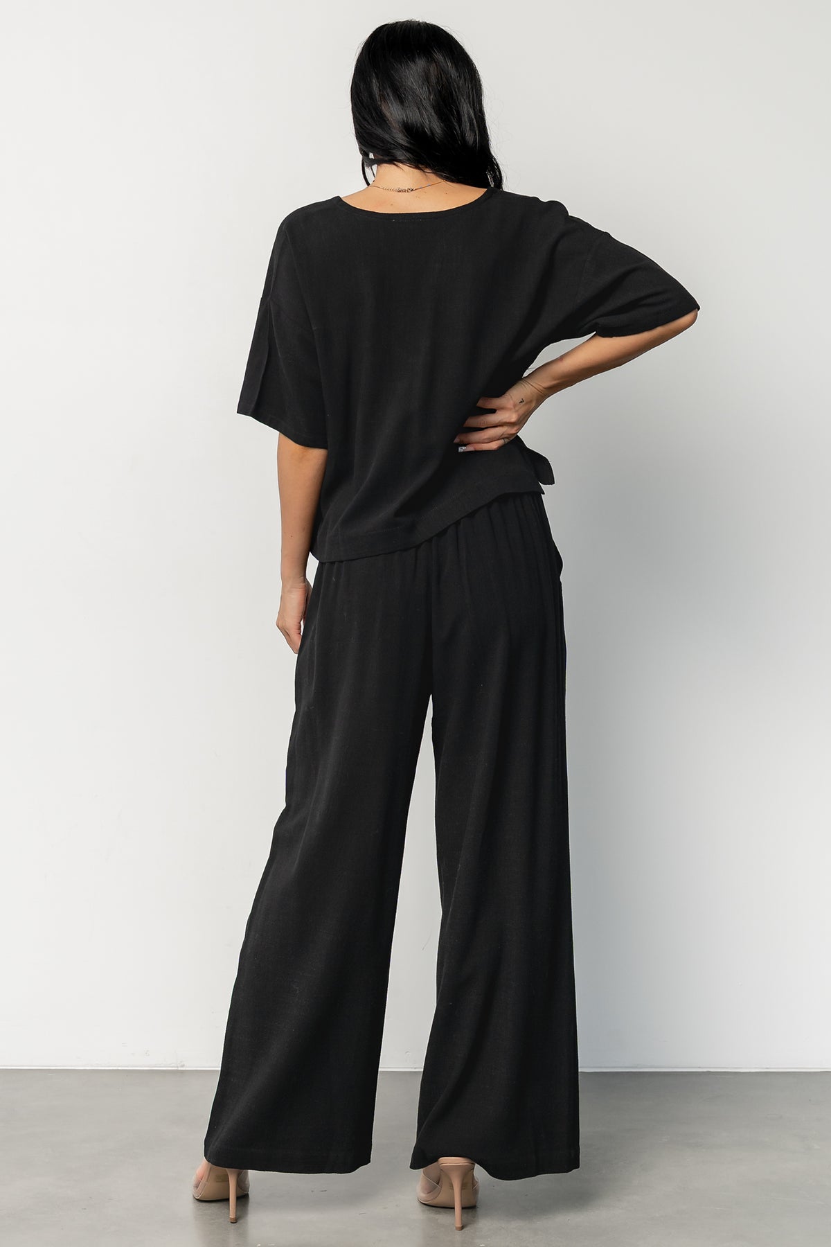 Back view of model in Timbre set showing elastic waist with tie and relaxed fit of the wide-leg pants.