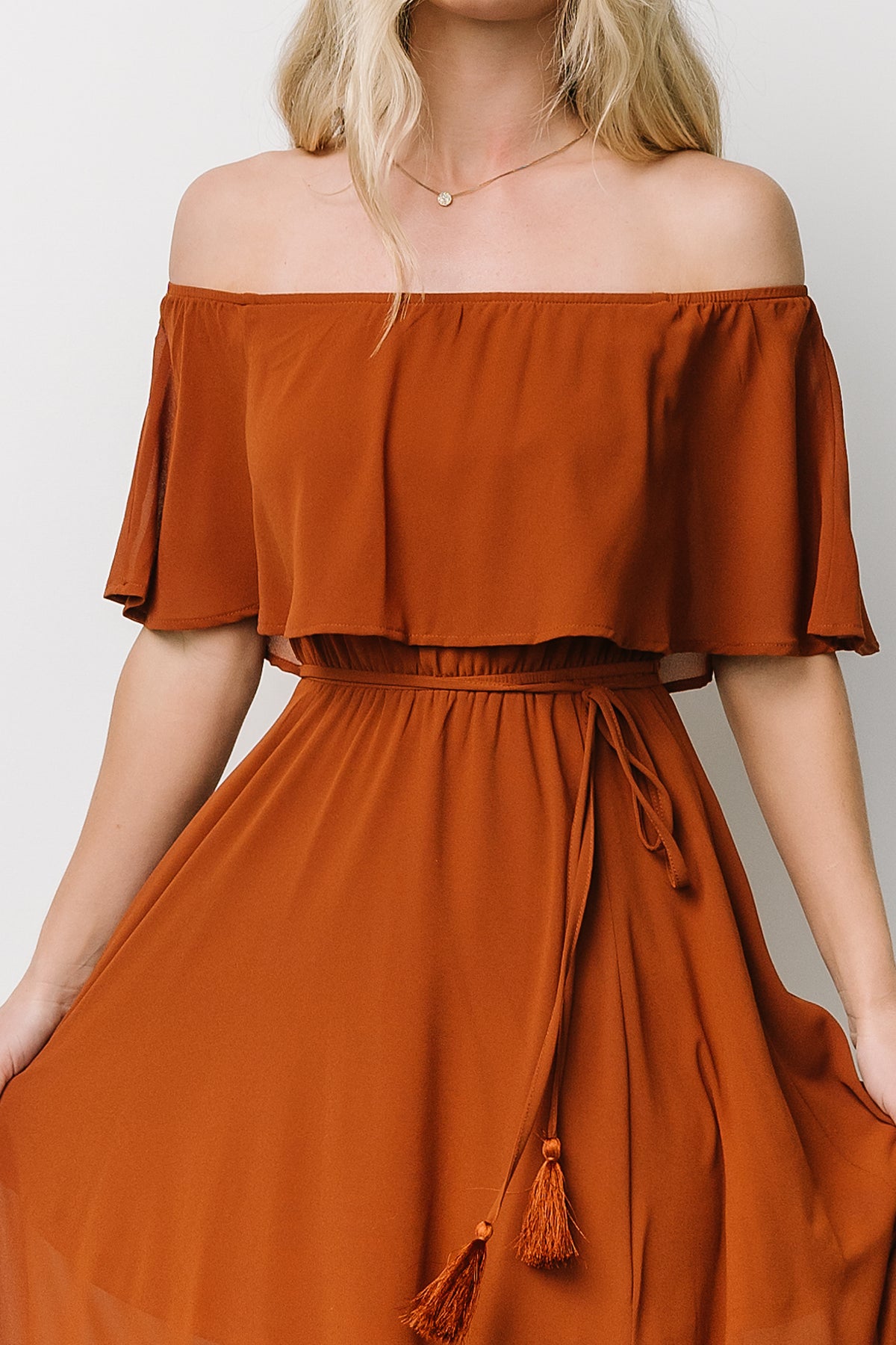 Back view of the Spice off-shoulder maxi dress showing elasticized shoulders and full-length flowing silhouette.