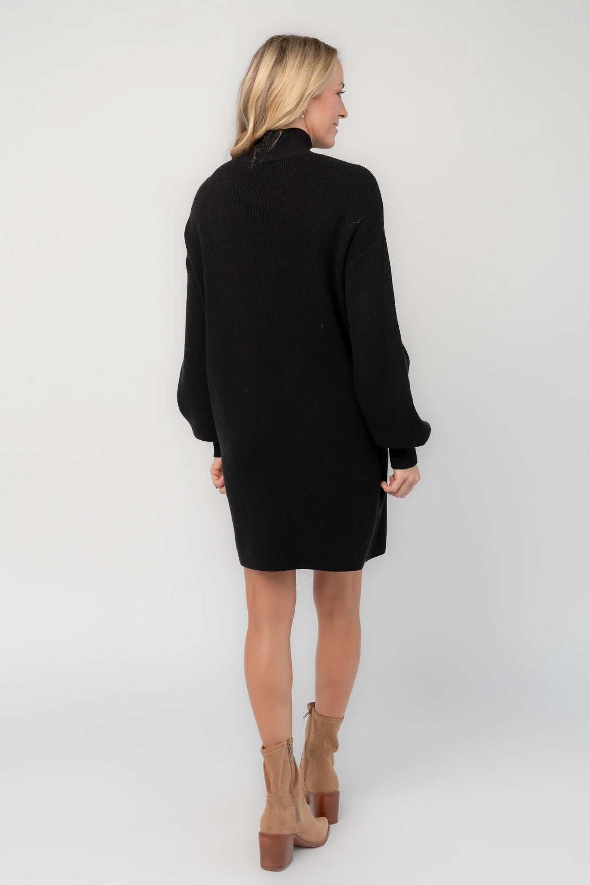 Black knit sweater dress with a mock neckline, long balloon sleeves, dropped shoulders, and a relaxed above-the-knee silhouette.