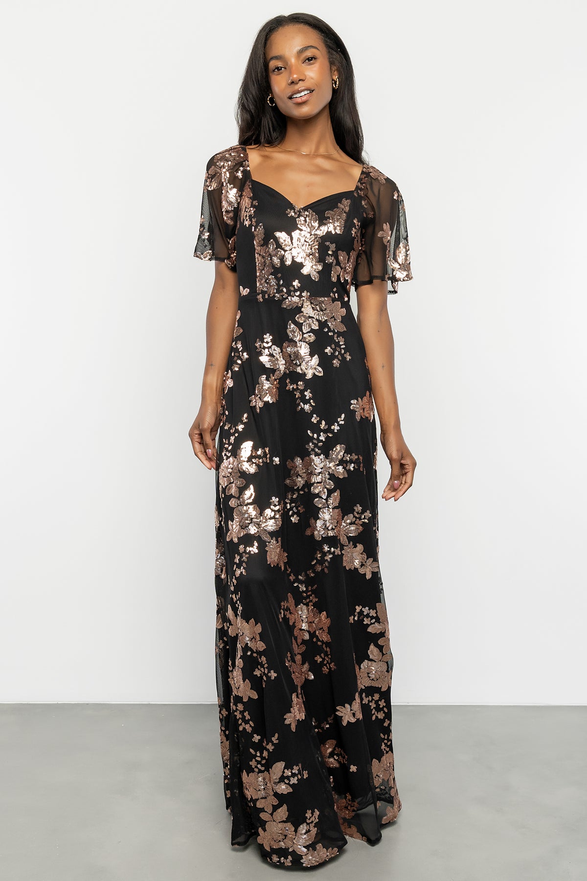 Detail view of the sweetheart neckline, princess seam shaping and delicate flutter sleeve with mesh overlay and lining.