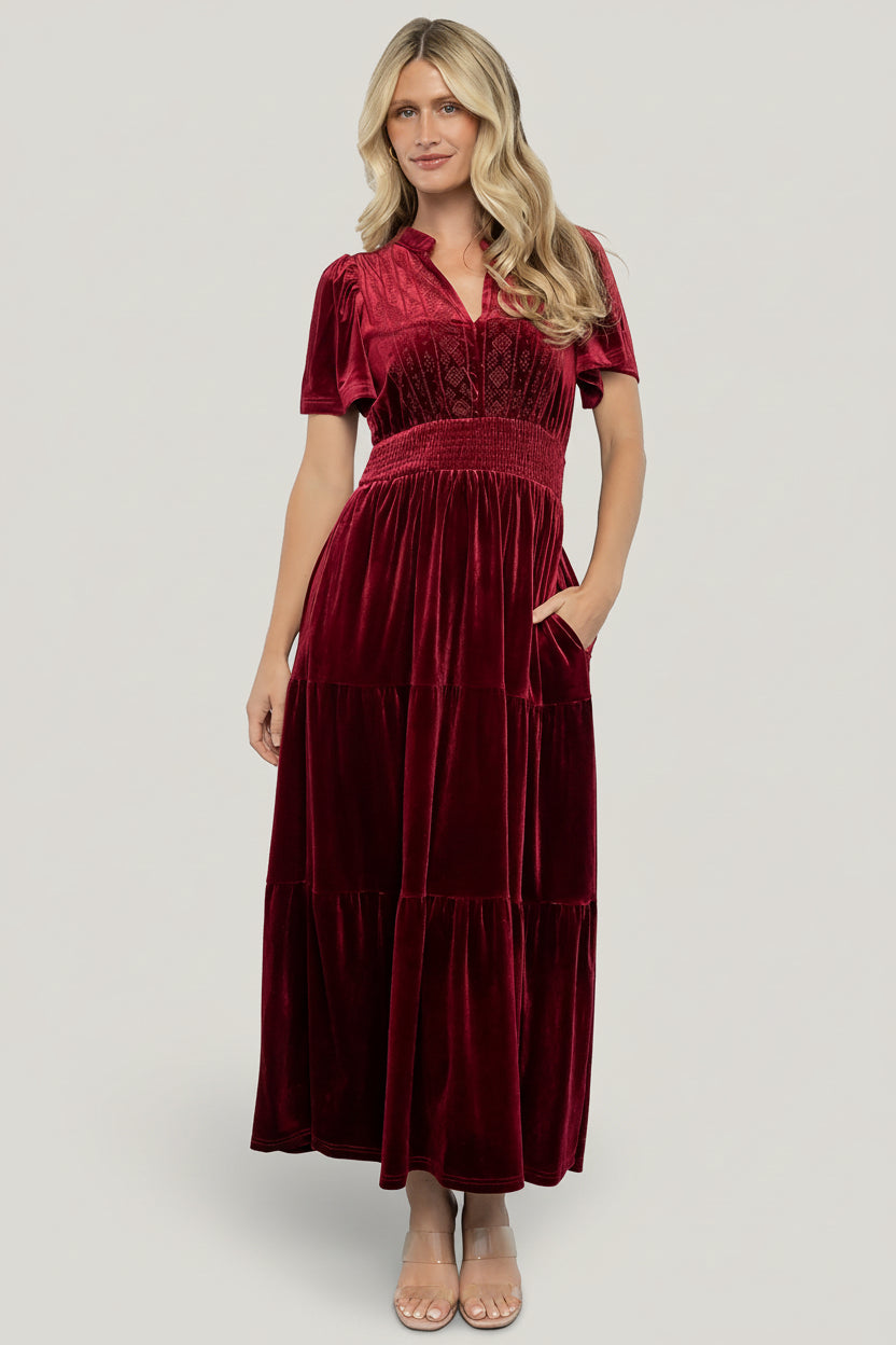 Back and hem detail of Maida cranberry velvet maxi dress displaying tiered skirt movement and the full lining silhouette for coverage.